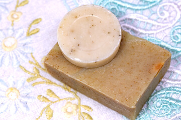 Handmade natural herbal soaps. Natural herbal soaps on towel with floral pattern.