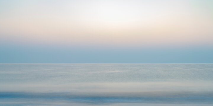 Abstract background of the Indian Ocean at sunrise, featuring a blurry sea landscape with soothing pastel colors. Perfect for presentations or as a versatile backdrop.