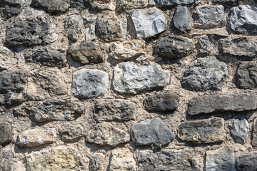 Architecture textures, detailed view of a traditional paired masonry, mixed granite and limestone wall, used on a fortress castle wall