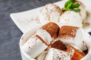 hot chocolate with marshmallows and ice cream balls on a black background