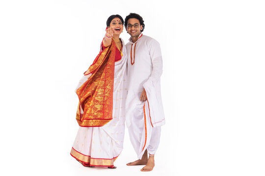Portrait of Bengali couple looking and pointing at camera