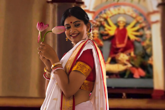 Bengali woman with lotus at puja pandal on the occasion of Durga Puja