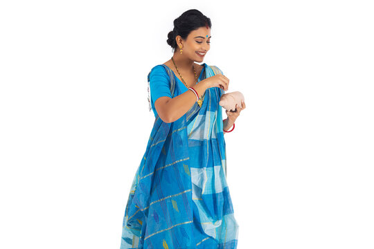 Bengali woman putting coin into the piggy bank