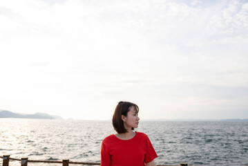 Fototapeta premium 夕暮れの海にいる女性