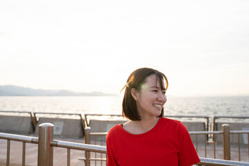 Fototapeta premium 夕暮れの海にいる女性