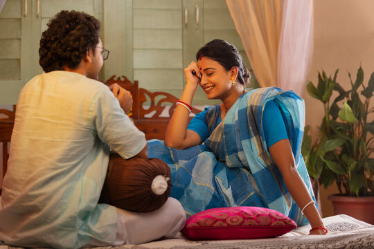 Portrait of Bengali couple talking on bed