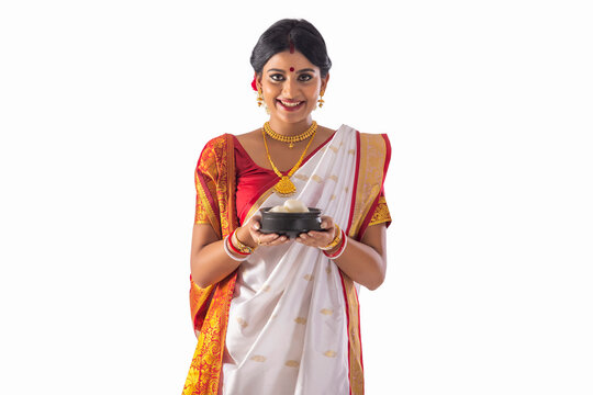 Portrait of Bengali woman standing with a rosogolla handi