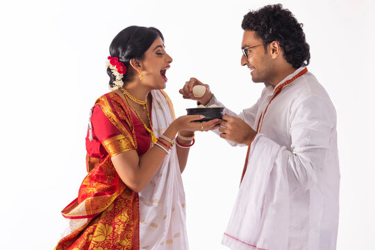 Portrait of Bengali man feeding rosogolla to his wife