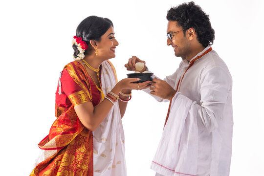 Portrait of Bengali man feeding rosogolla to his wife