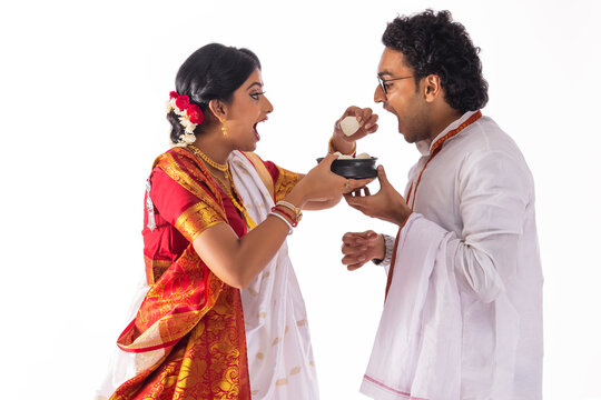 Portrait of Bengali woman feeding rosogolla to her husband