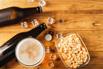 bottles beer with snack on wood background