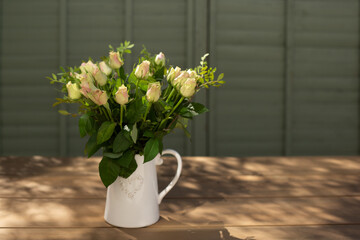 A bouquet of roses in a white jug