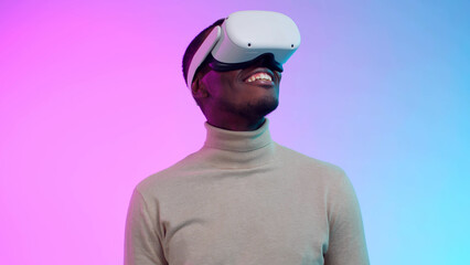 African-American man model in virtual reality headset isolated over neon background