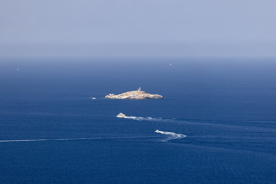 Ships cross the waters of Tyrrhenian Sea between the islands of the Tuscan archipelago, in the center of the picture is one of its tiniest with Faro dello Scoglietto di Portoferraio. Island of Elba