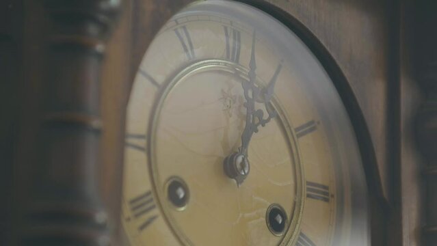 Beautiful shot of a detail of a 1920s deli pendulum clock from the 1900s, a vintage ancestral object with decorated hands and Roman numerals to mark time
