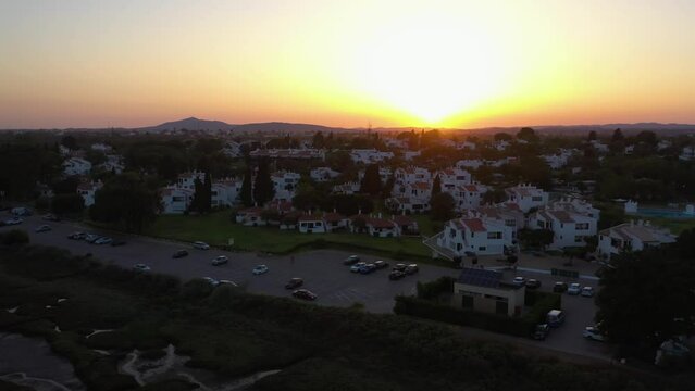 Aerial view of the Pedras Del Rei village, sunset in Tavira, Portugal - tracking, drone shot