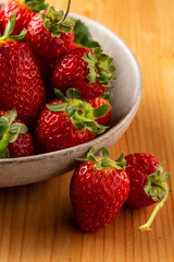 Fresh tasty Strawberries in a rustic bowl on a wooden table

