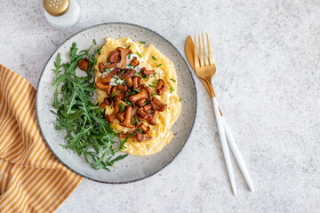 Traditional scrambled eggs with fresh chanterelle and arugula