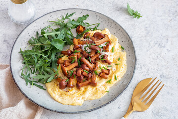 Traditional scrambled eggs with fresh chanterelle and arugula