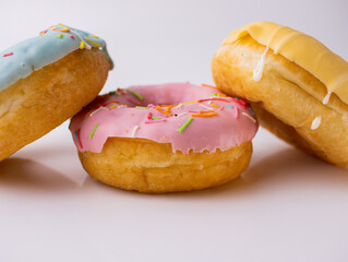 In Europe. Donuts with sprinkles on the table and a white background. Three types of donuts.