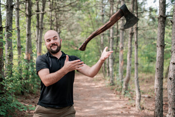 The bearded man smiles and throws an axe. The axe hovers in the air