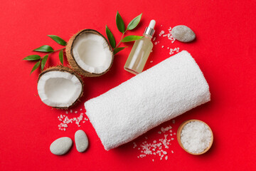 Coconut with jars of coconut oil and cosmetic cream on colored background. Top view. Free space for...