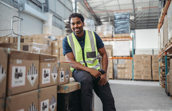 Happy warehouse employee smiling at the camera in a logistics centre