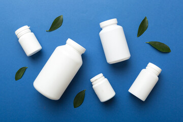 supplement pills with medicine bottle health care and medical top view. Vitamin tablets. Top view mockup bottle for pills and vitamins with green leaves, natural organic bio supplement, copy space