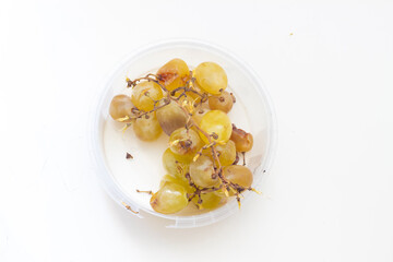 bunch of broken grapes in plastic bowl