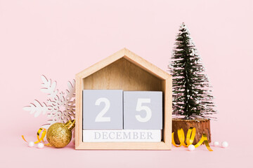 25 december. Christmas composition on colored background with a wooden calendar, with a gift box,...