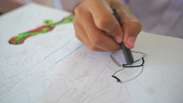 The child's hand is painting and drawing with color on paper, creative, imagination