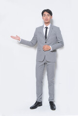 Full body young businessman wearing gray suit, white shirt ,black, tie ,welcome, gesture standing in studio