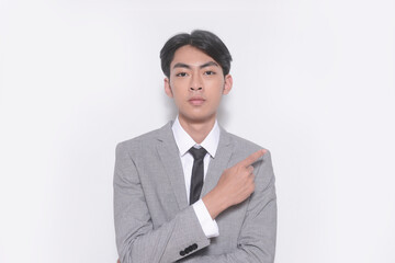 young businessman wearing gray suit, white shirt ,black, tie with finger to side  standing in studio