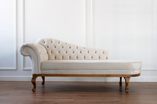 Baroque sofa. Vintage furniture. Pastel beige sofa with carriage screed. Restoration of vintage furniture. Furniture manufacturing. Interior Design. Soft selective focus.
