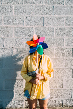 Woman holding pinwheel toy in front of face