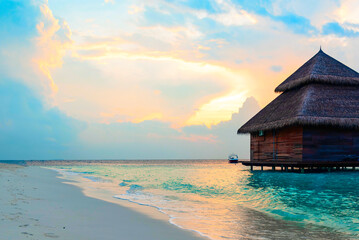 view of the water villas at sunrise in the Maldives, the concept of luxury travel