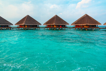 Fototapeta premium view of the water villas at sunrise in the Maldives, the concept of luxury travel