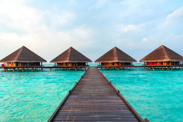 Fototapeta na wymiar view of the water villas at sunrise in the Maldives, the concept of luxury travel