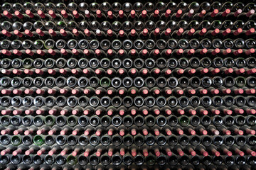 Obraz premium Many bottles in a row stacked on a winery shelf