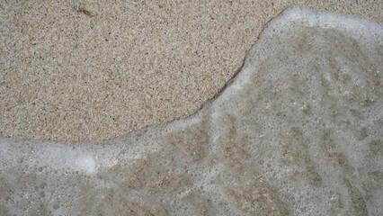 Fototapeta na wymiar Caribbean beach sand with grains of white sand and sea wave that wets the shore