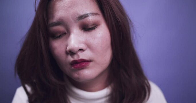 Woman portrait with problem of depression emotion sad alone on purple background