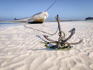 Anchor of small fishing boat on white beach in zanzibar tansania