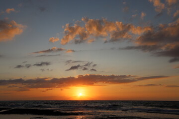 Naklejka na ściany i meble The sun sets below the horizon on the Mediterranean Sea in northern Israel.