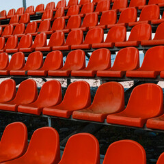 Close up of plastic red stadium seats for the public. The shot is without brands or persons.