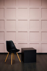 Black chair over pink wall in the hipster interior modern room.