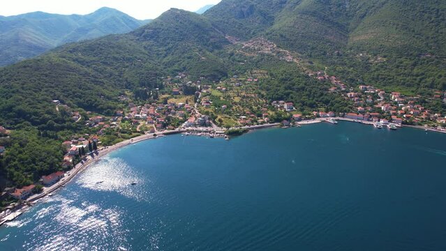 Aerial View of Picturesque Coastline of Kotor Bay, Montenegro, Scenic Coastal Road, Homes and Ferry Station in Kamenari, Drone Shot