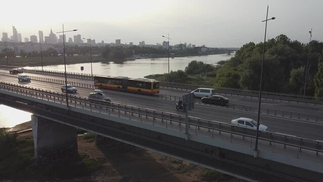 Aerial drone footage of a bridge in Warsaw Poland with traffic flowing and downtown city skyline behind it and visla river
