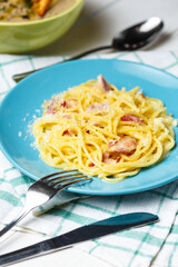 Plate with carbonara pasta and cutlery