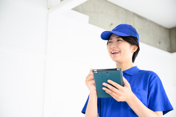 メモや見積をとる引っ越しの作業員のイメージ　あおり　タブレット