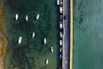 Small boats and sailing yachts in a harbor. Water sport and hobby concept. Aerial top down view.